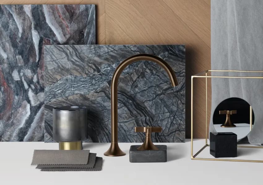 Materiaalcollage met natuursteen, hout en een messing kraan